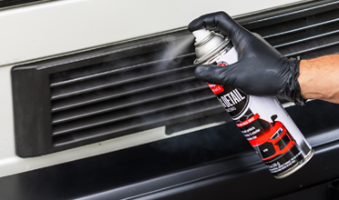 Spraying trim dressing on a car grille